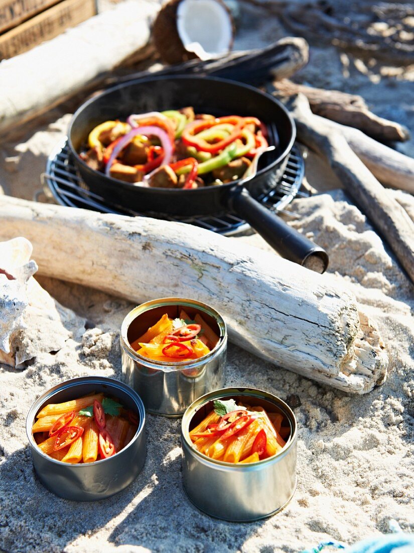 Penne pasta with chilli, and chicken with pepper for a Caribbean picnic on a beach