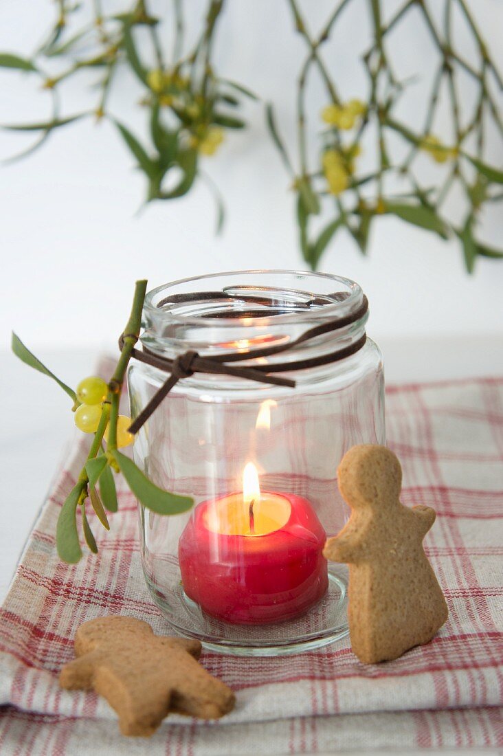 A lantern with a burning candle, spiced biscuits and mistletoe