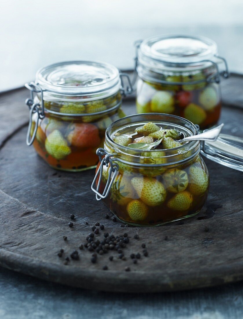 Pickled unripe strawberries in glass jars