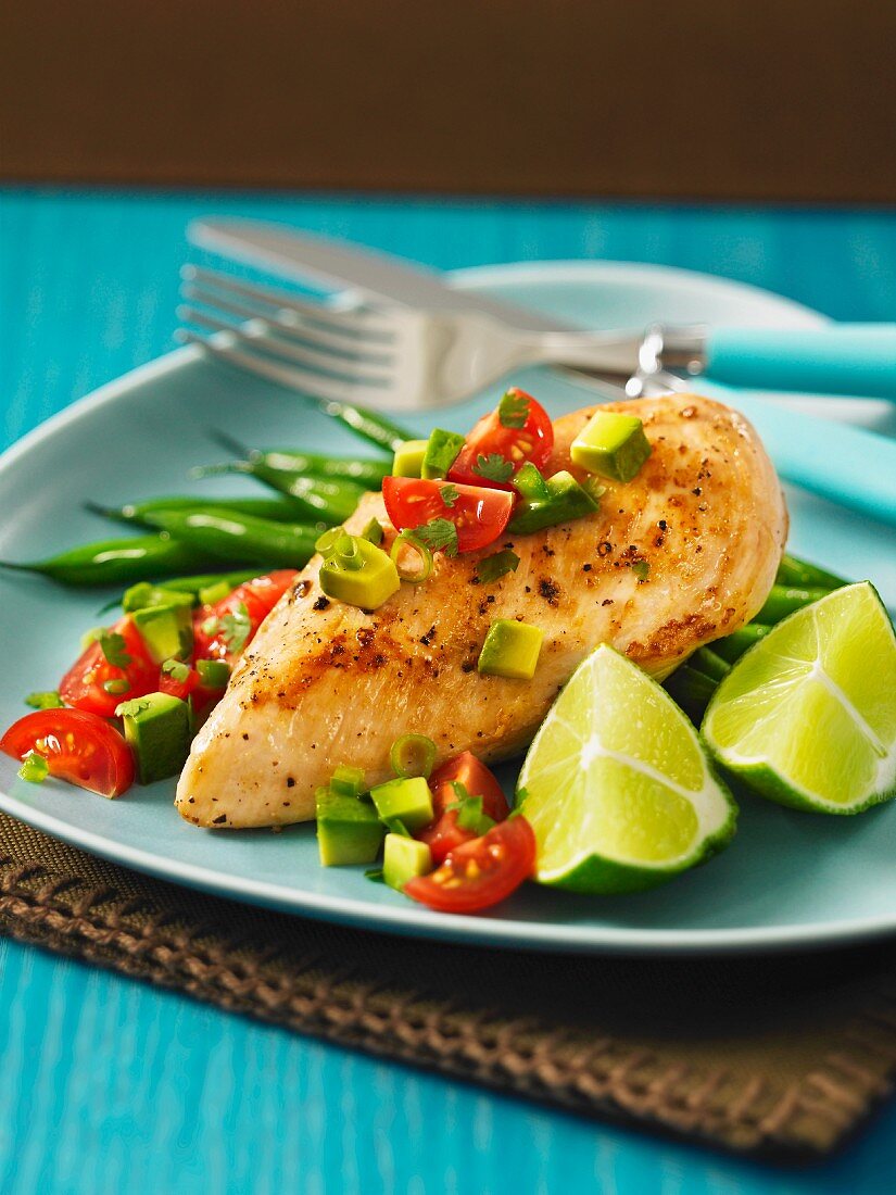 Chicken breast on a bed of green beans with a tomato and avocado salsa