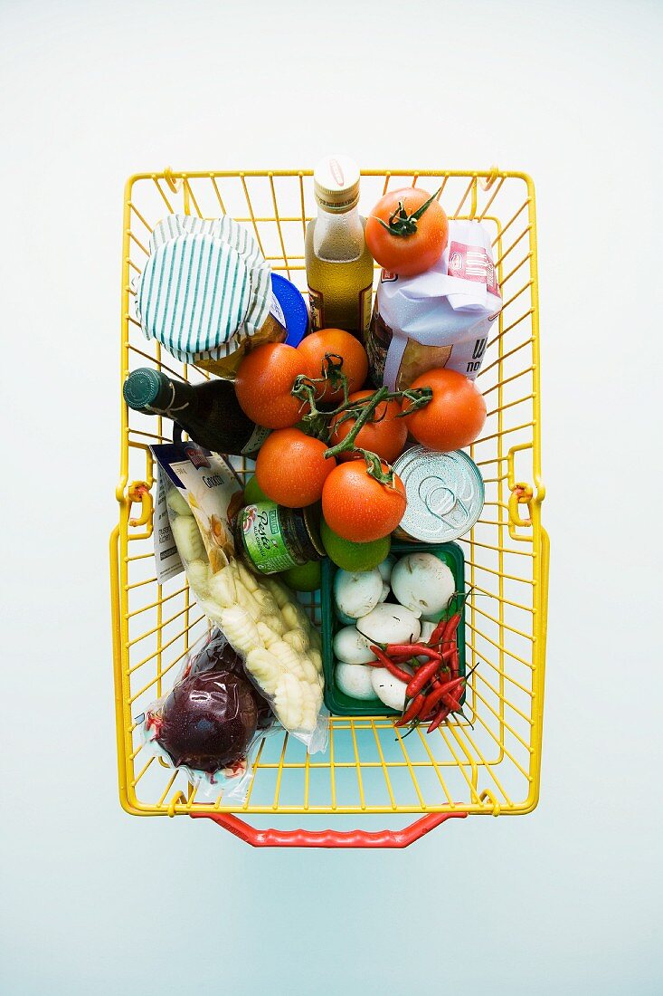 Einkaufskorb mit Gemüse und verschiedenen Lebensmitteln