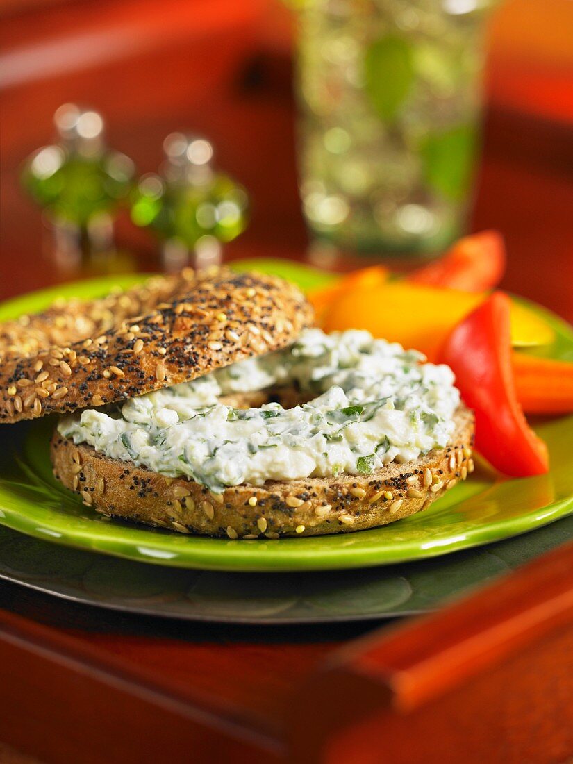 A poppy seed and sesame bagel with herb feta cheese