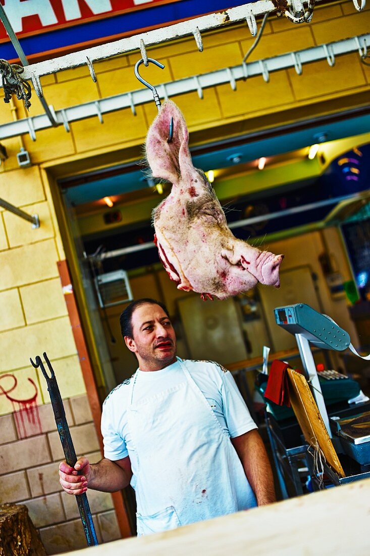 A butcher in front of his shop, Italy