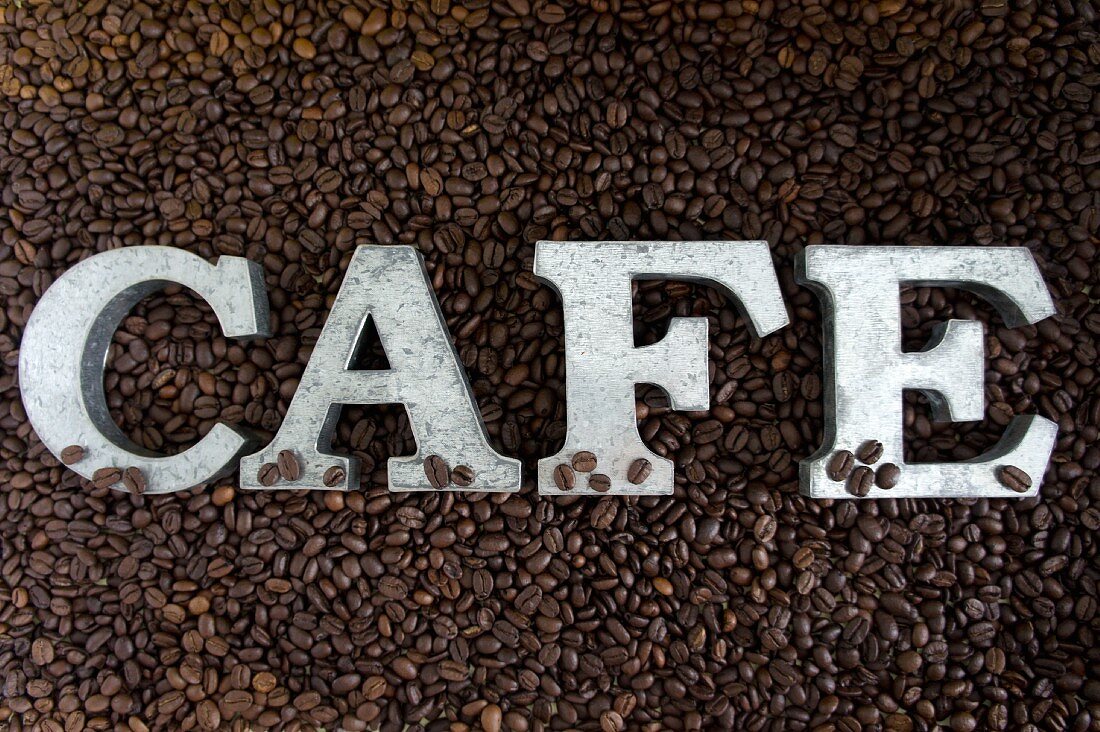 Schriftzug CAFE auf Kaffeebohnen