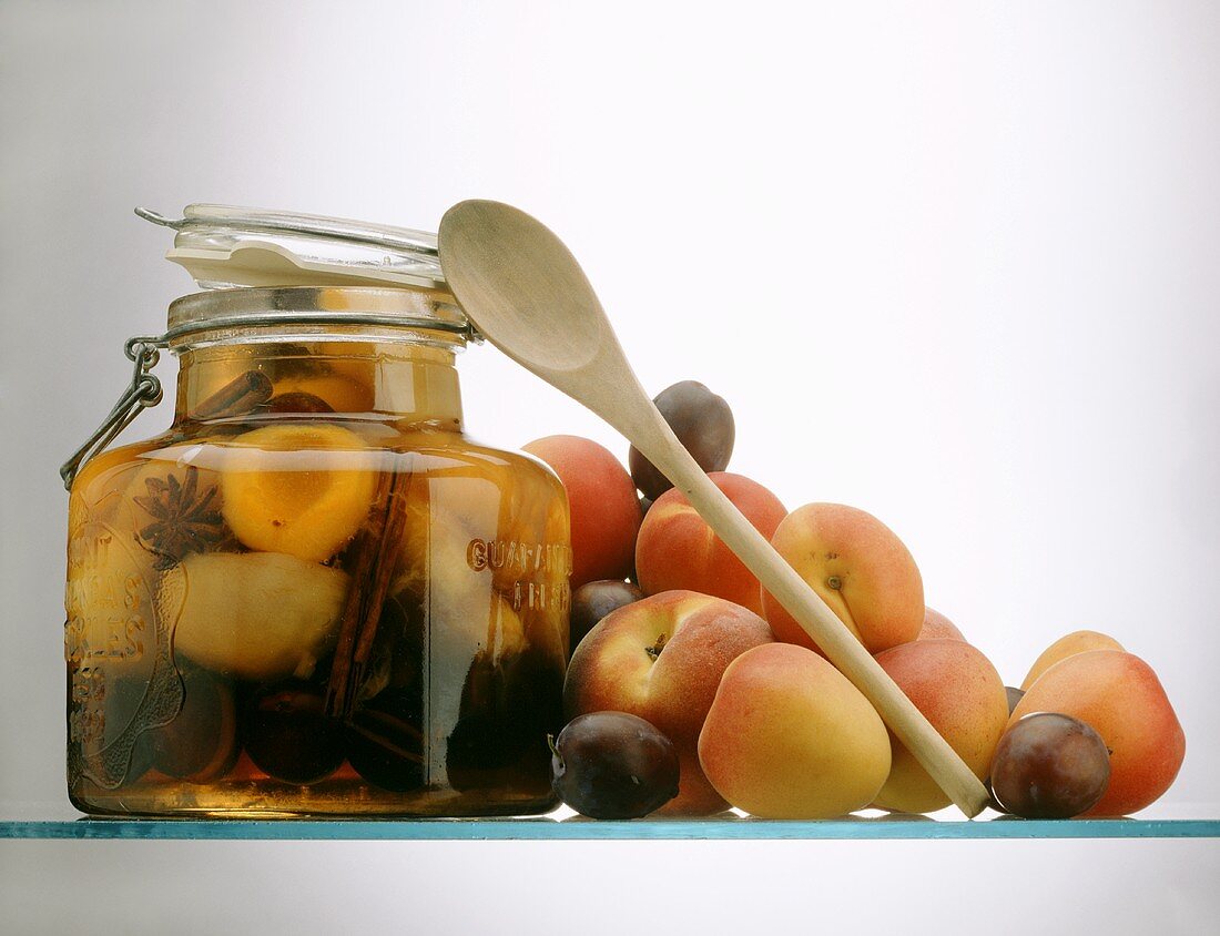 Stone Fruit Preserved in a Jar; wooden Spoon