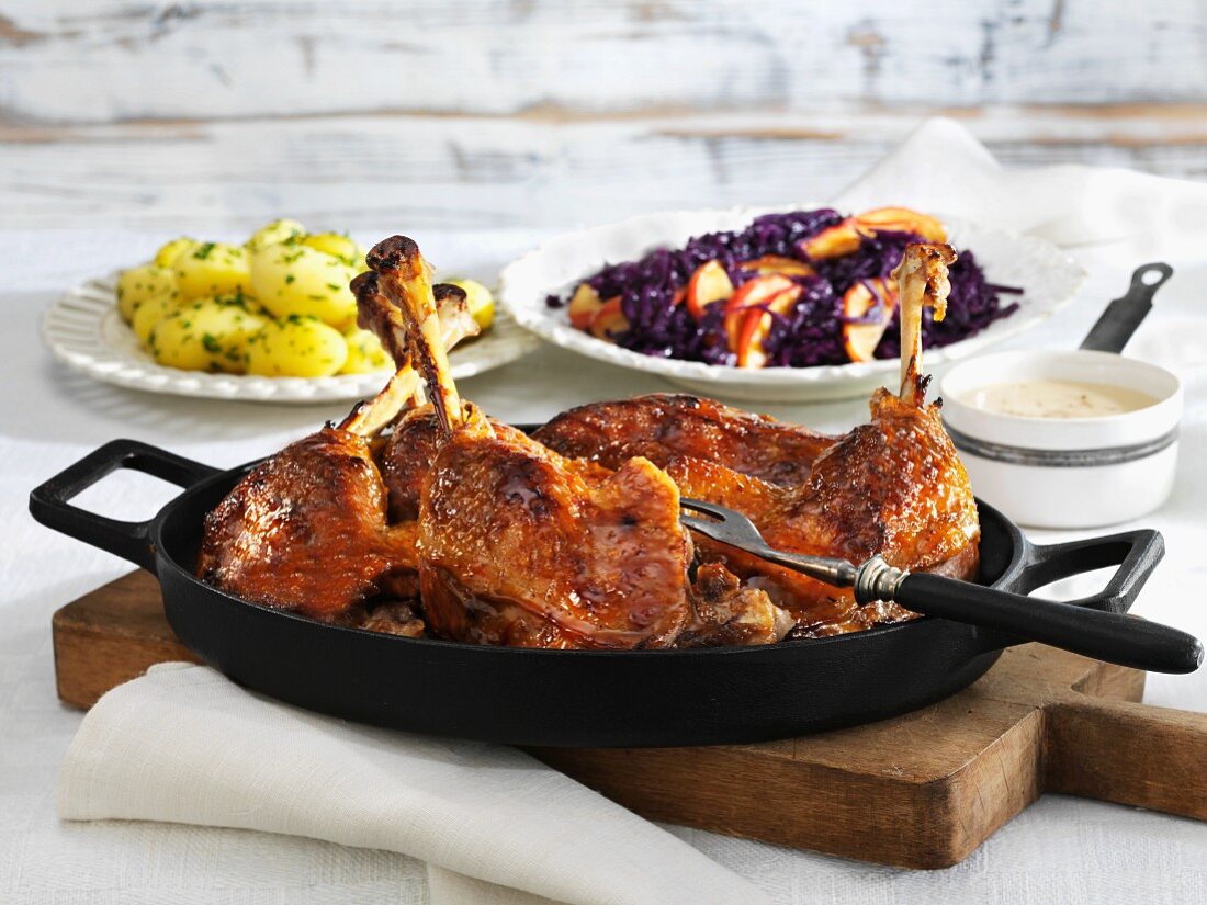 Sweet and sour goose legs with apple red cabbage and salted potatoes