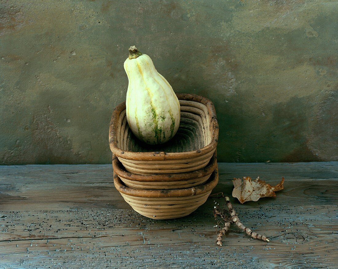 A green squash in a woven dish