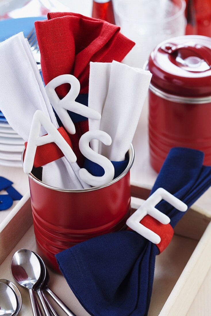 White china letters used as initial tags on napkin rings and napkins in red can