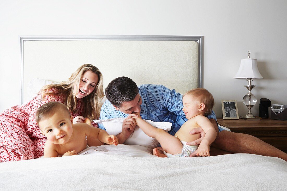 Happy family playing on bed