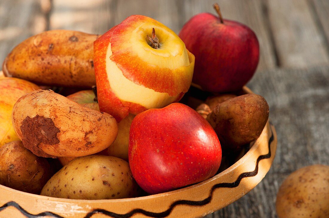 Kartoffeln und Äpfel in einer Keramikschale
