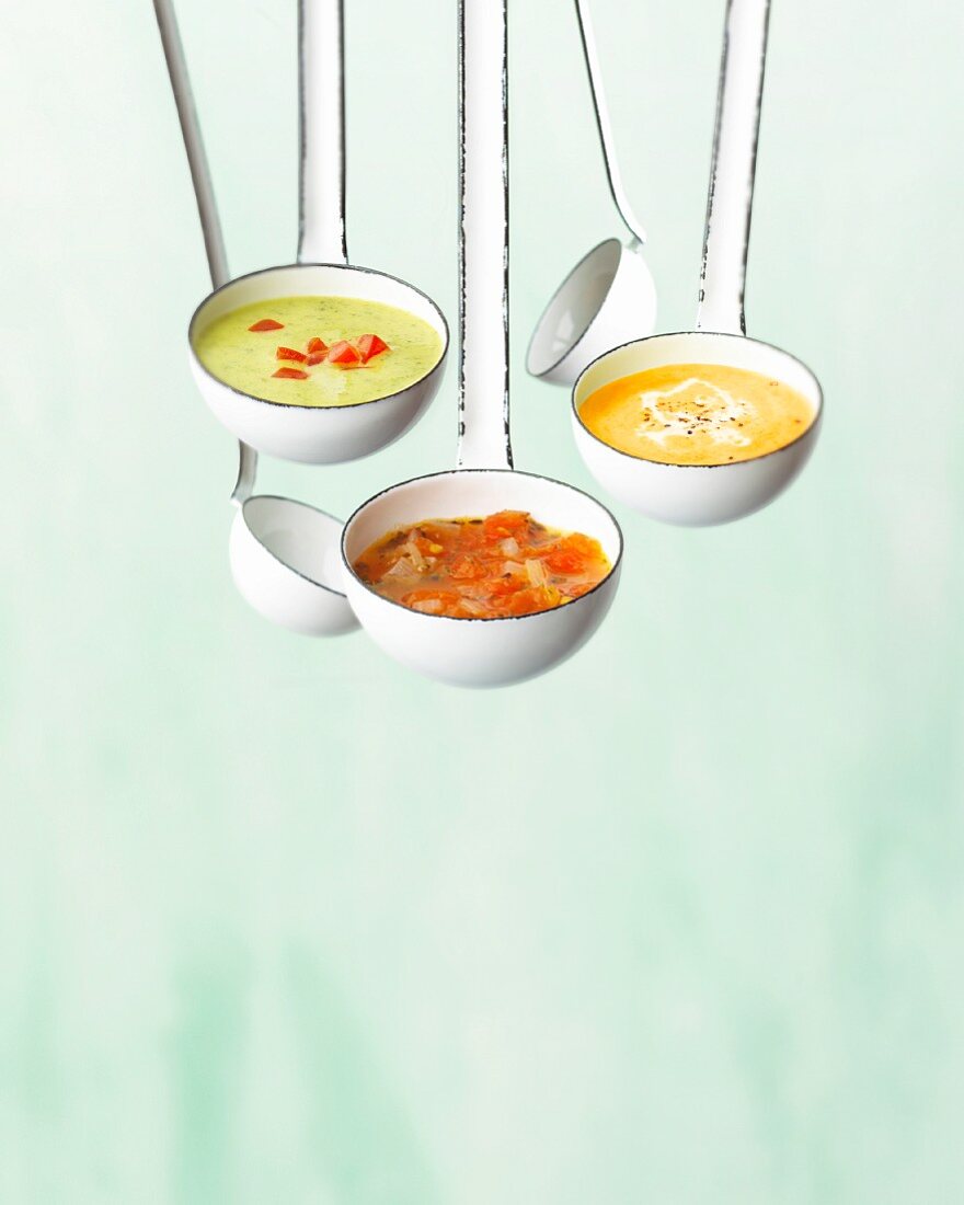 Three different soups in ladles