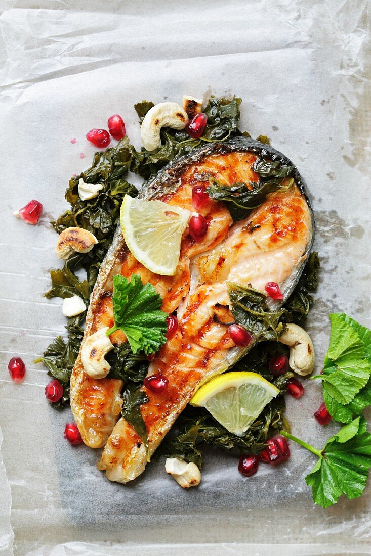 Fried salmon steak with lemon and pomegranate seeds