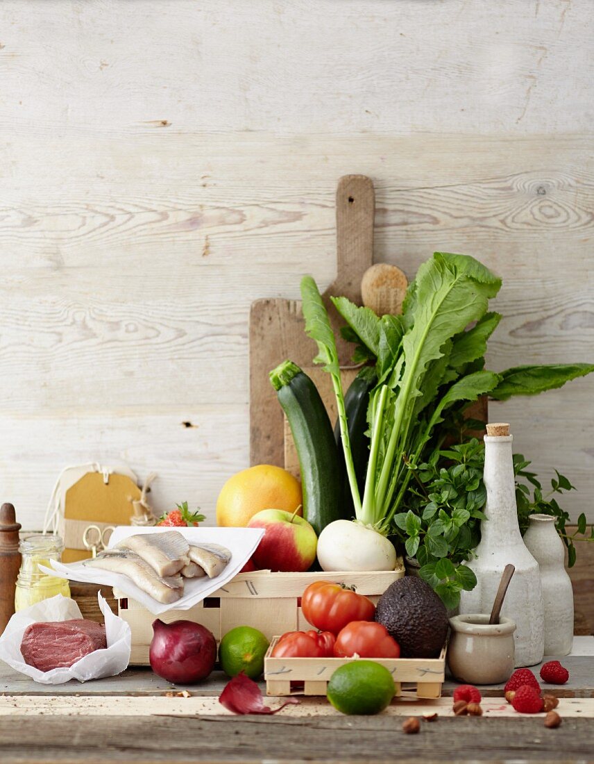 An arrangement of vegetables, fruit, herbs, fish and beef