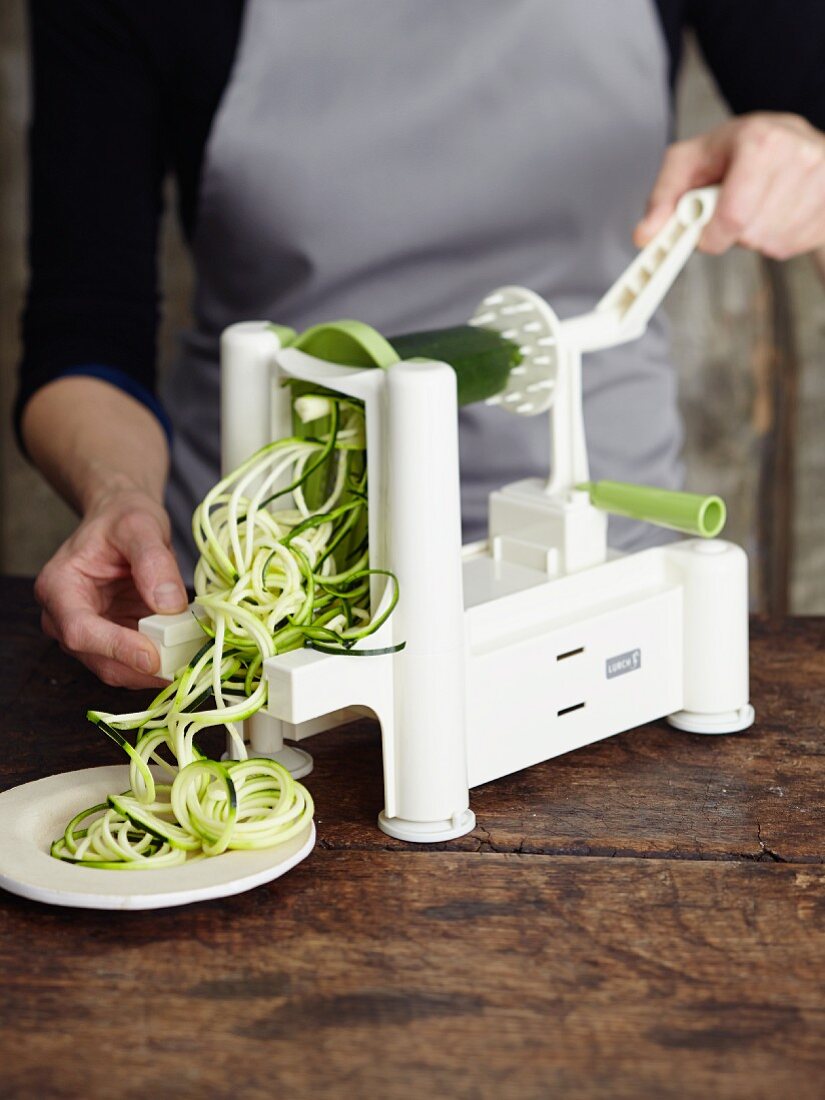 Courgette being cut with a spiral cutter