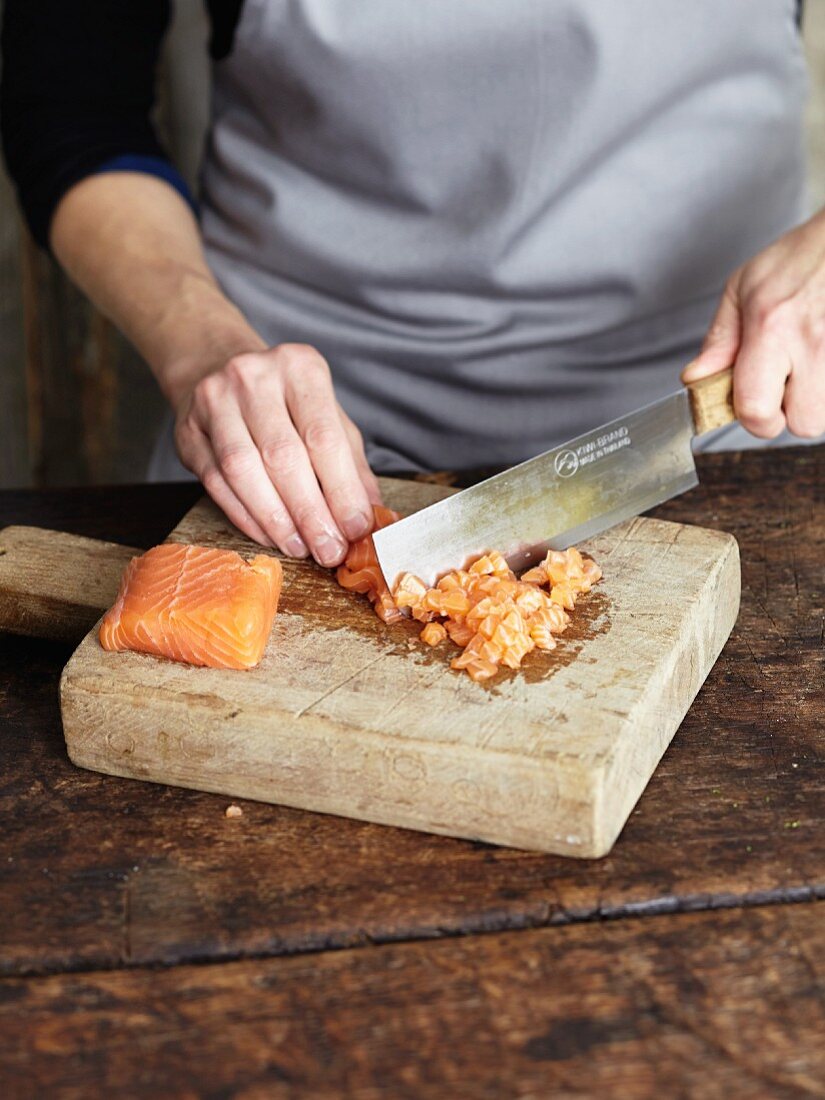 Raw fish fillet being chopped with an oriental knife