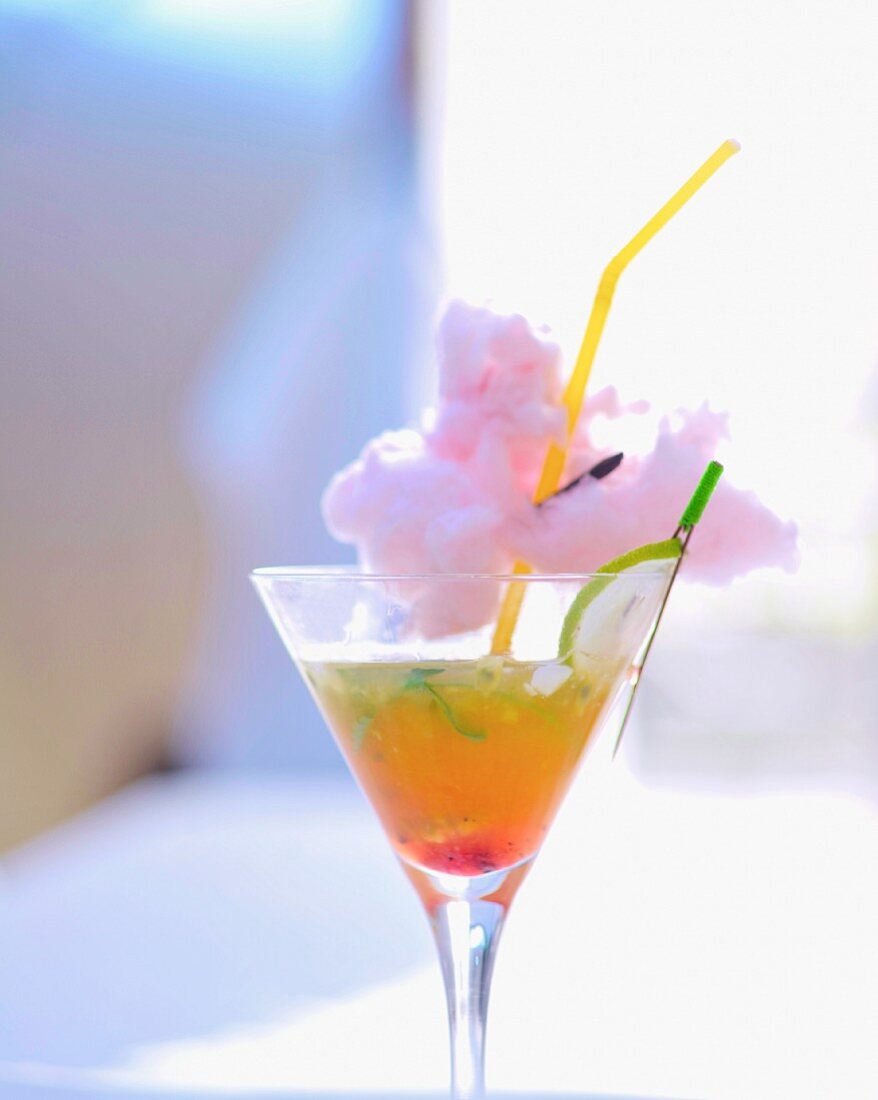 A cocktail garnished with candy floss