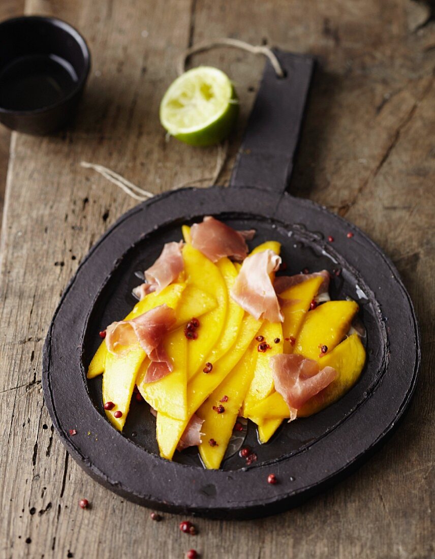 Mango carpaccio with raw ham and hazelnut oil