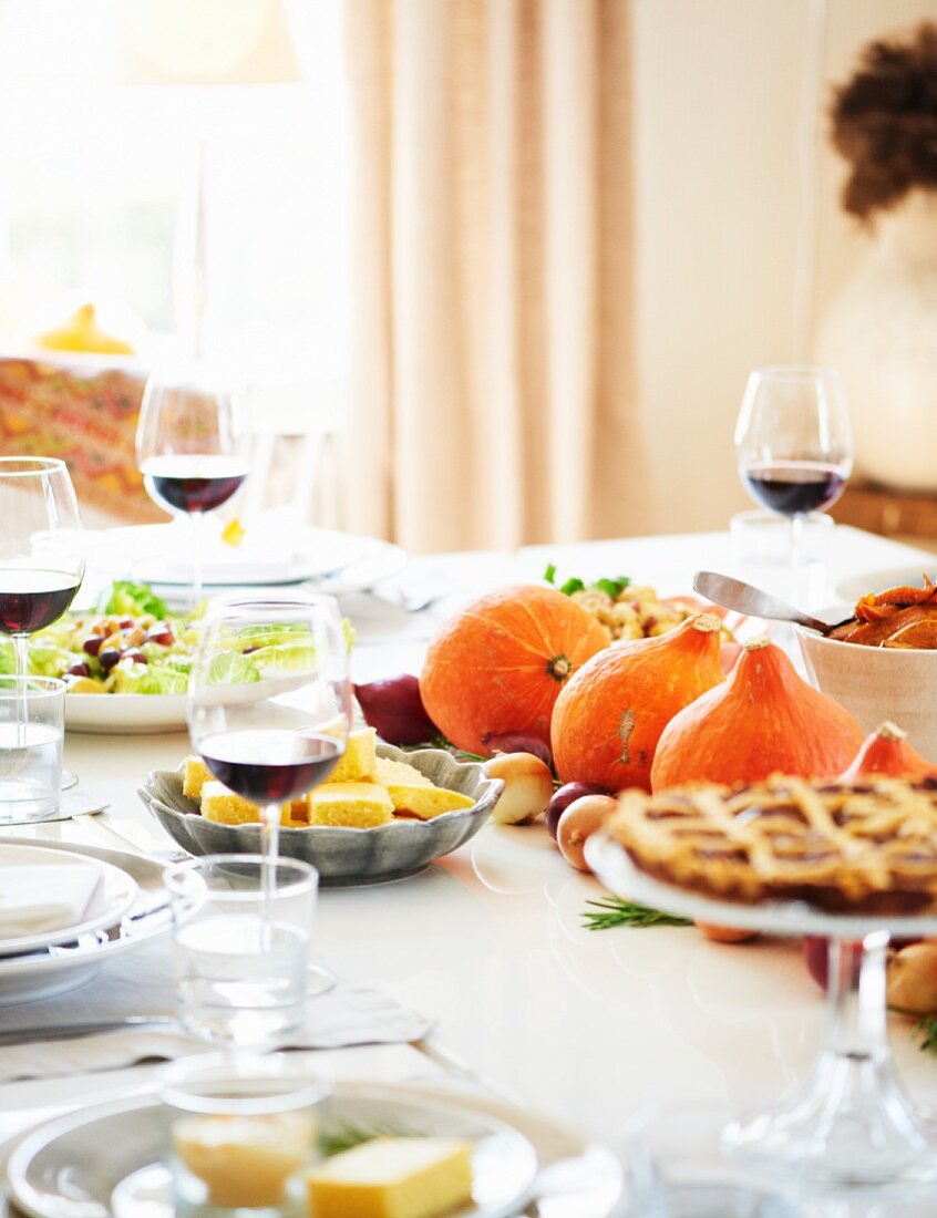 Gedeckter Tisch zu Thanksgiving mit Truthahn, Beilagen, Pecanpie und Rotwein