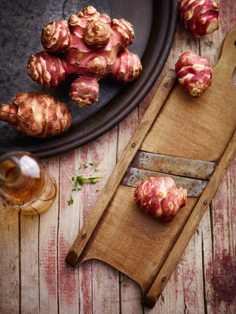 Jerusalem artichokes on a plate and a grater