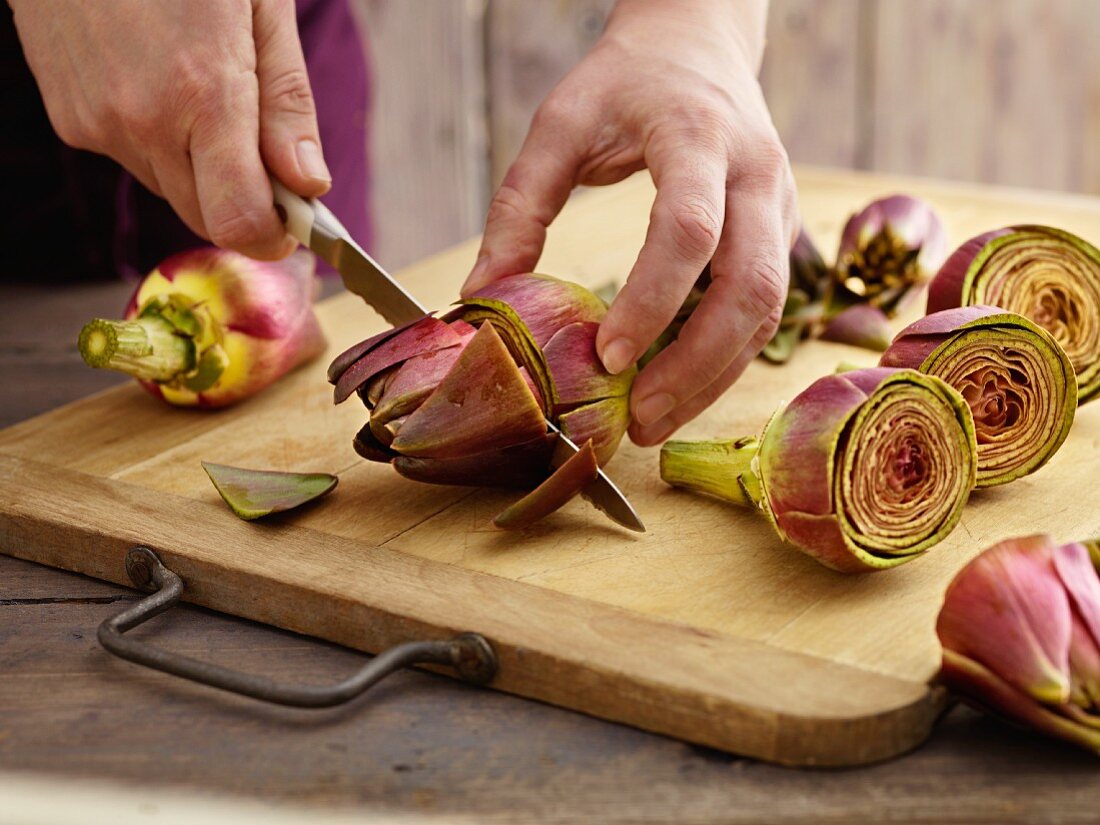 Artichokes being prepared: tops being cut off