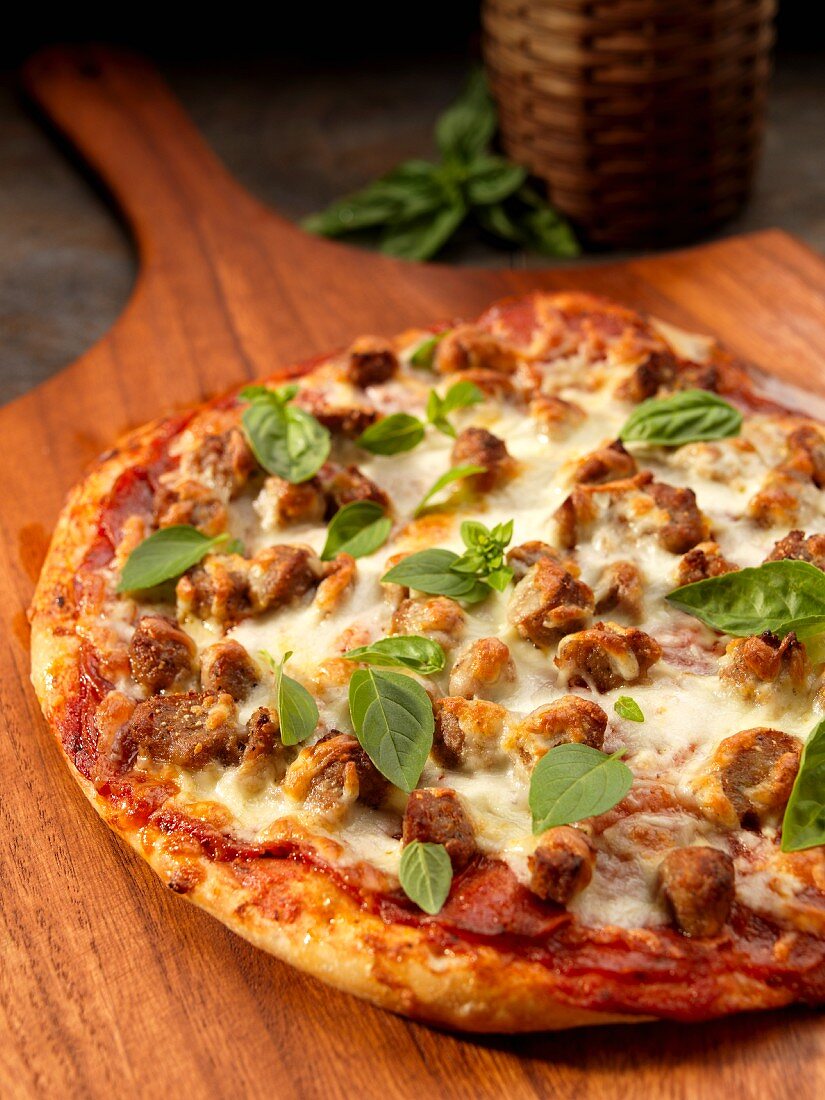 Rustic pizza with sausage, cheese and basil
