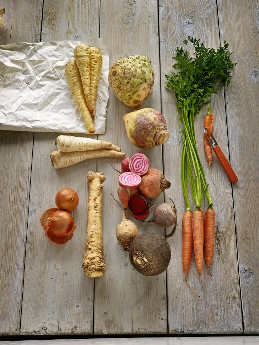 Various root vegetables on a wooden surface