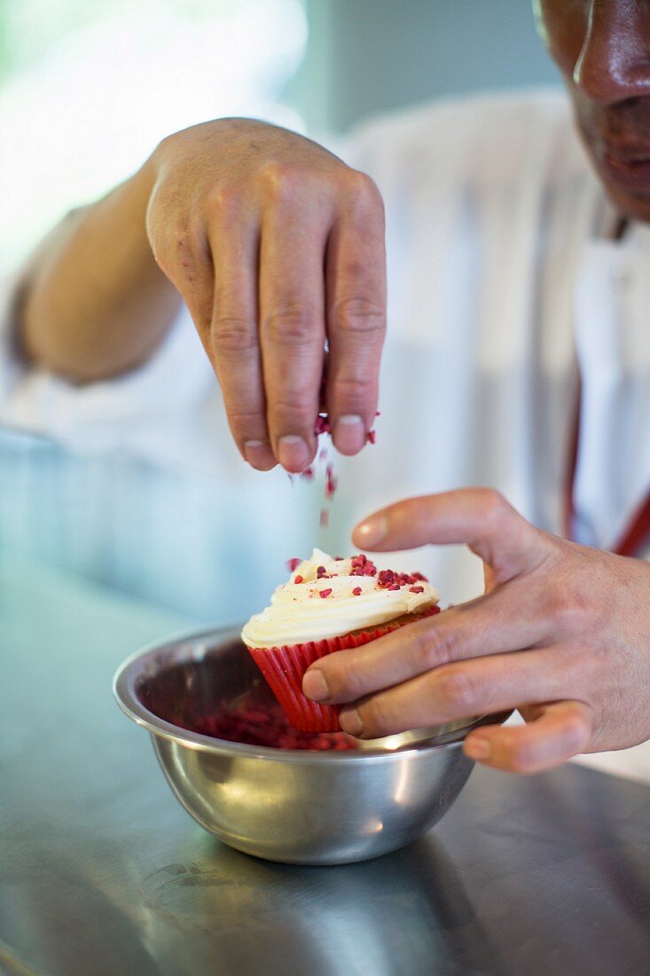 Red Velvet cupcakes being sprinkled with sugar
