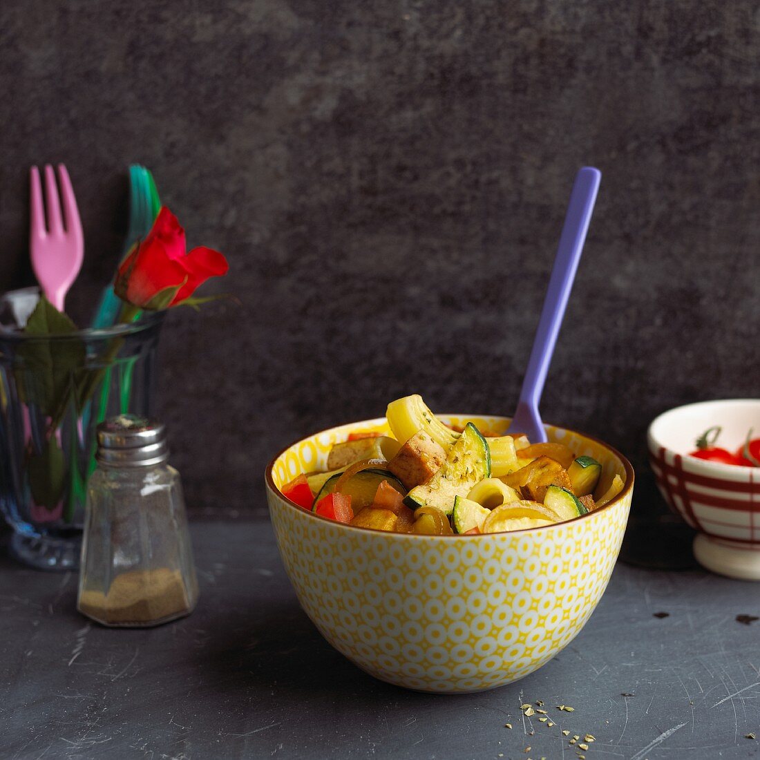 A bowl of rigatoni with courgettes, tomatoes and tofu