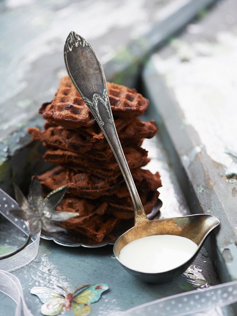 A stack of chocolate waffles with cream