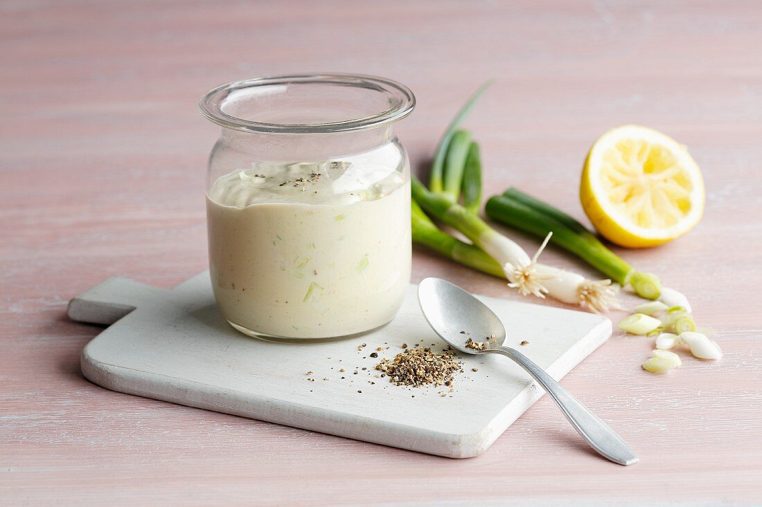 A jar of tahin cream with spring onions