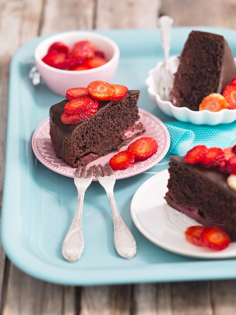 Three slices of chocolate cake with strawberries
