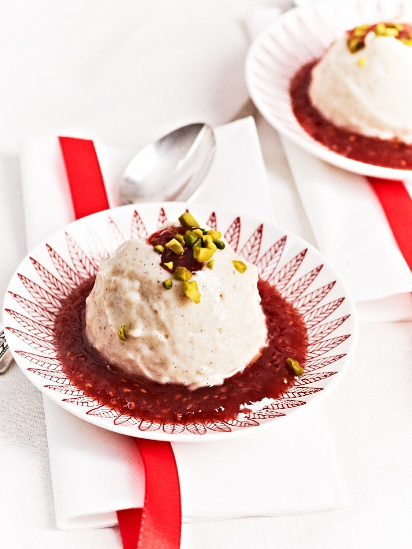 Vanilla pudding with raspberry sauce and pistachios