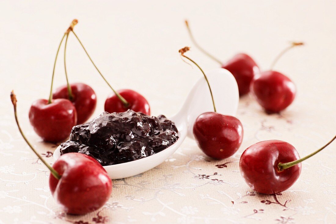 A spoonful of cherry jam and fresh cherries