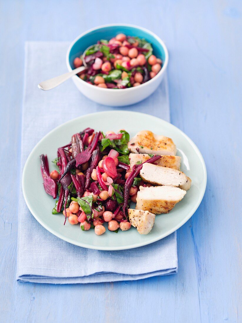 Warm beetroot salad with chickpeas, onions, beetroot leaves and grilled chicken breast