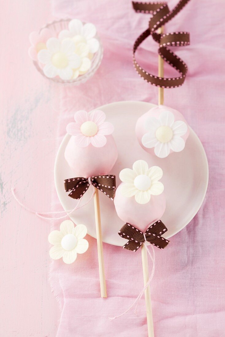 Birthday cake pops with sugared flowers and bows