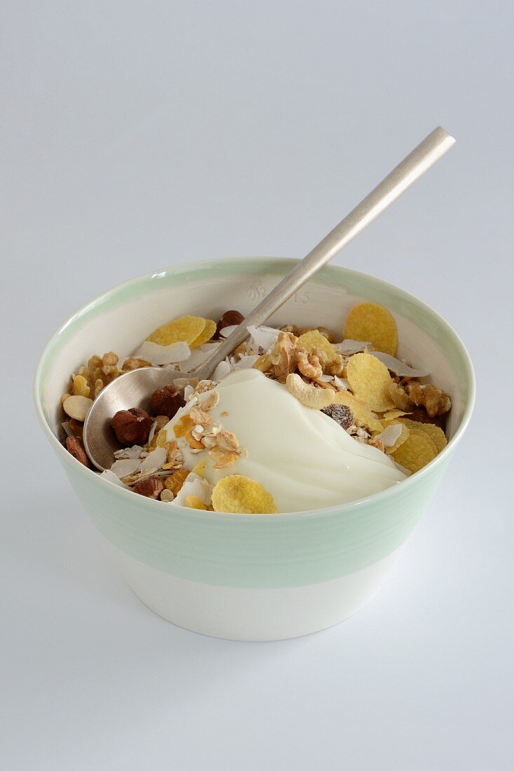 A bowl of muesli with yogurt against a white background