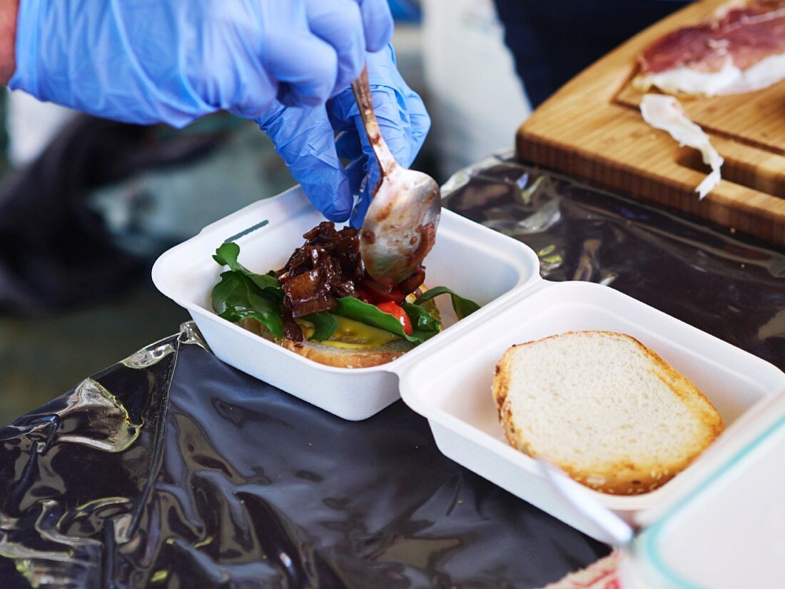 Food being placed in a polystyrene takeaway box (market in Pretoria, South Africa)