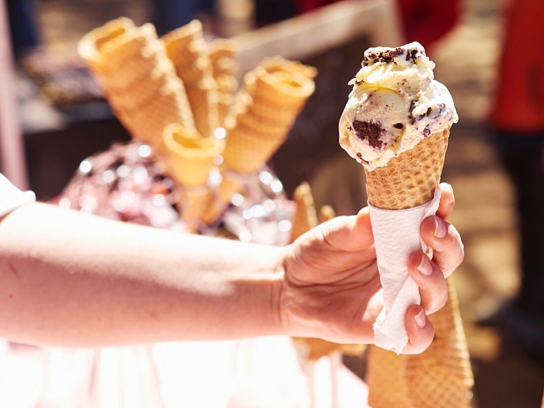 Hand hält Eiscreme in der Waffeltüte (Markt in Pretoria, Südafrika)