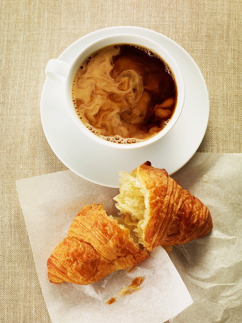 A cup of coffee and a croissant