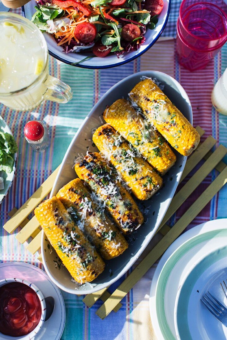 Grilled corn on the cob with herbs and cheese