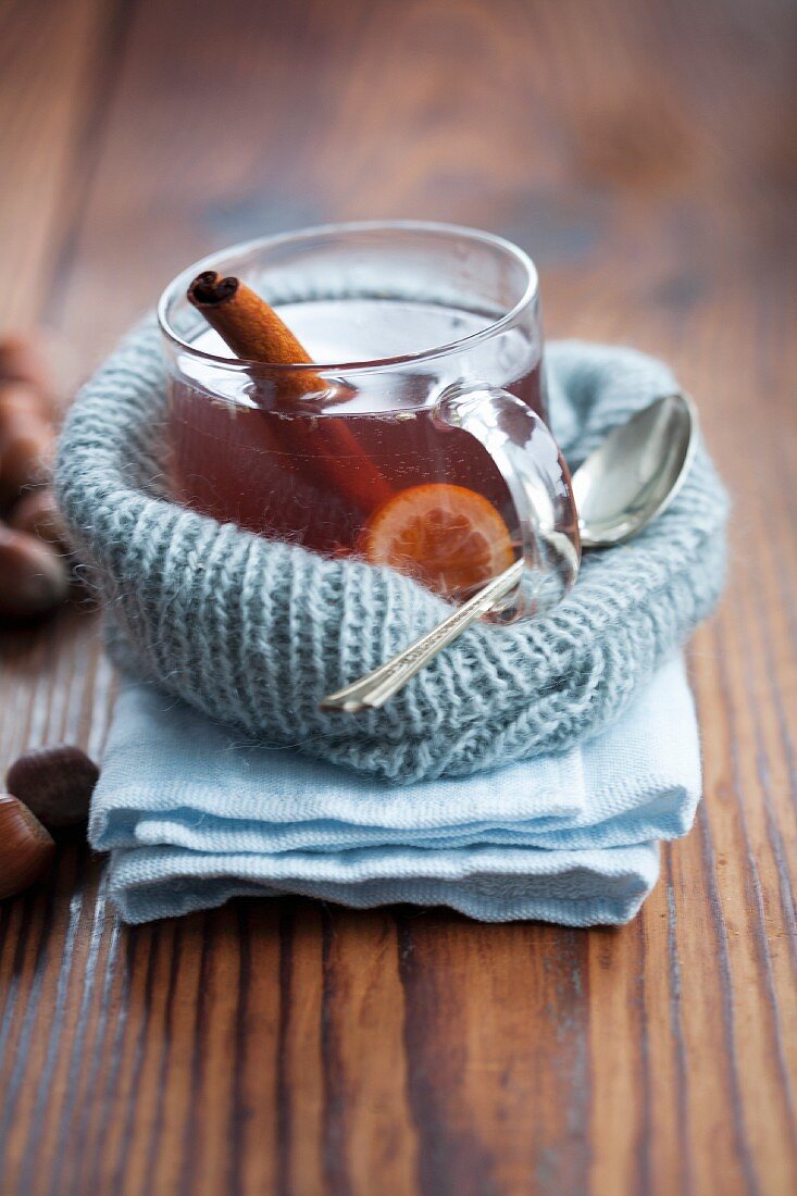 Orange punch with cinnamon sticks in a glass cup