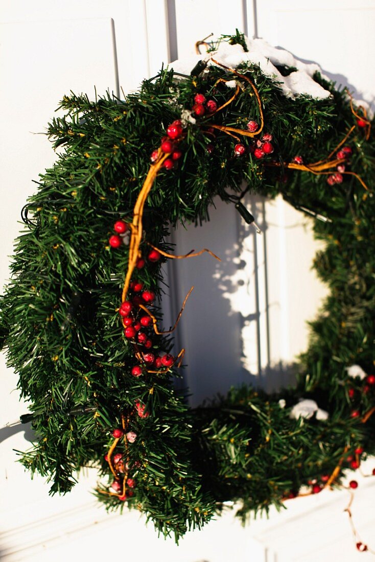 Advent wreath with red berries hanging on exterior door