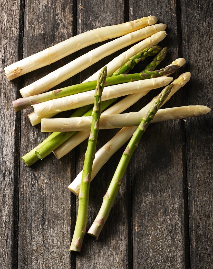 Weisser und grüner Spargel auf einem Holztisch