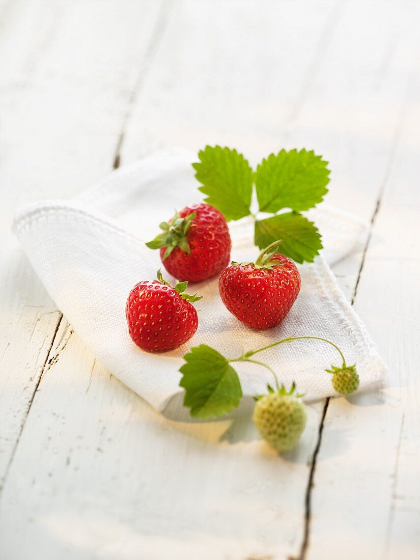 Erdbeeren mit Blättern auf Tuch