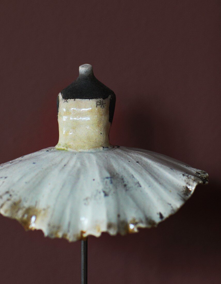 Painted, china torso wearing tutu on metal stand