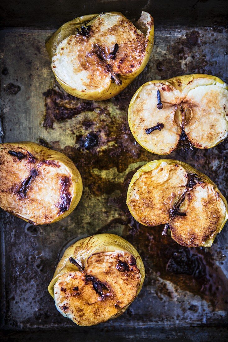 Baked apples with cloves on a baking tray
