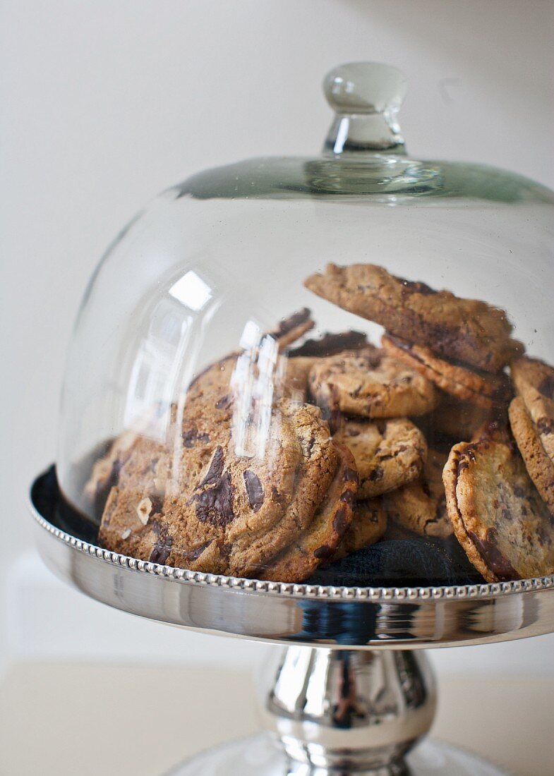 Biscuits on silver cake stand with glass cover