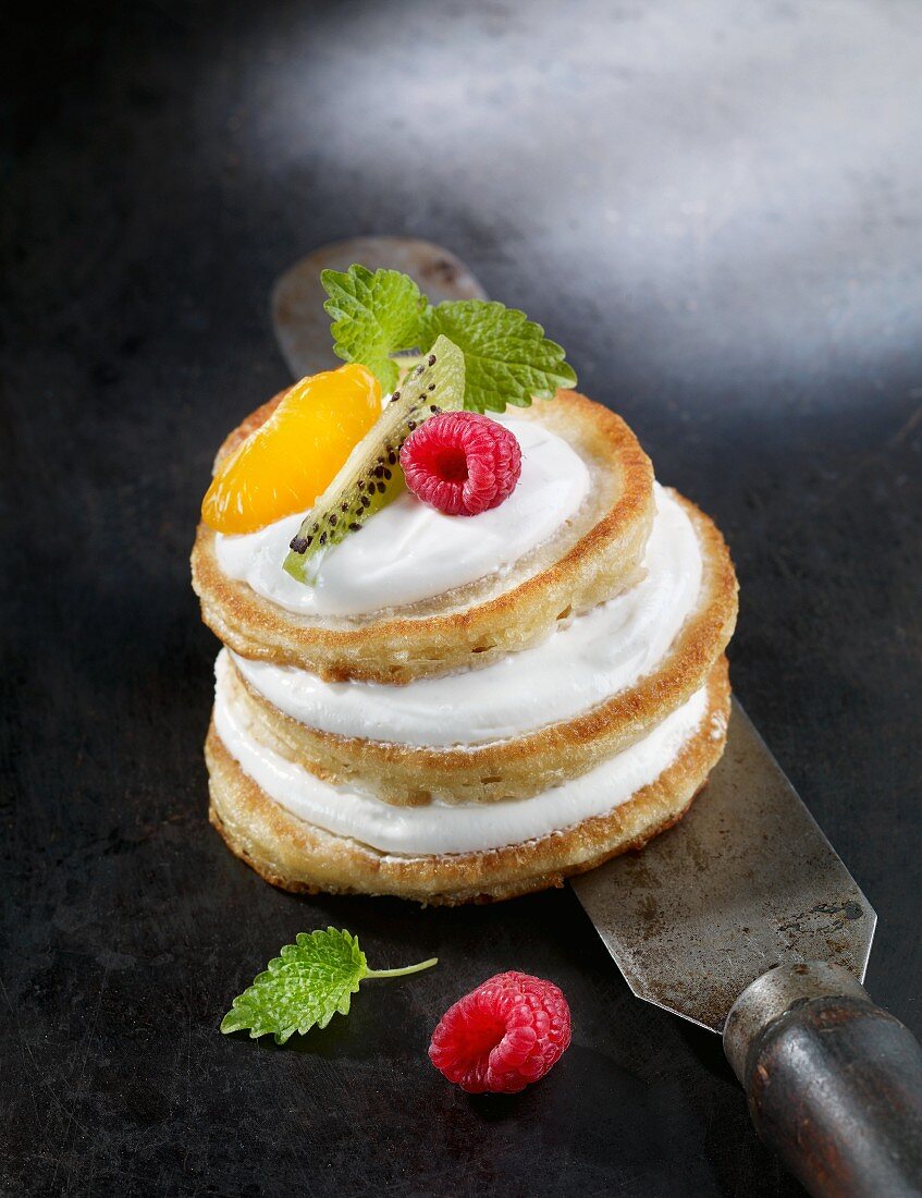 A pancake tower with fruit and mint