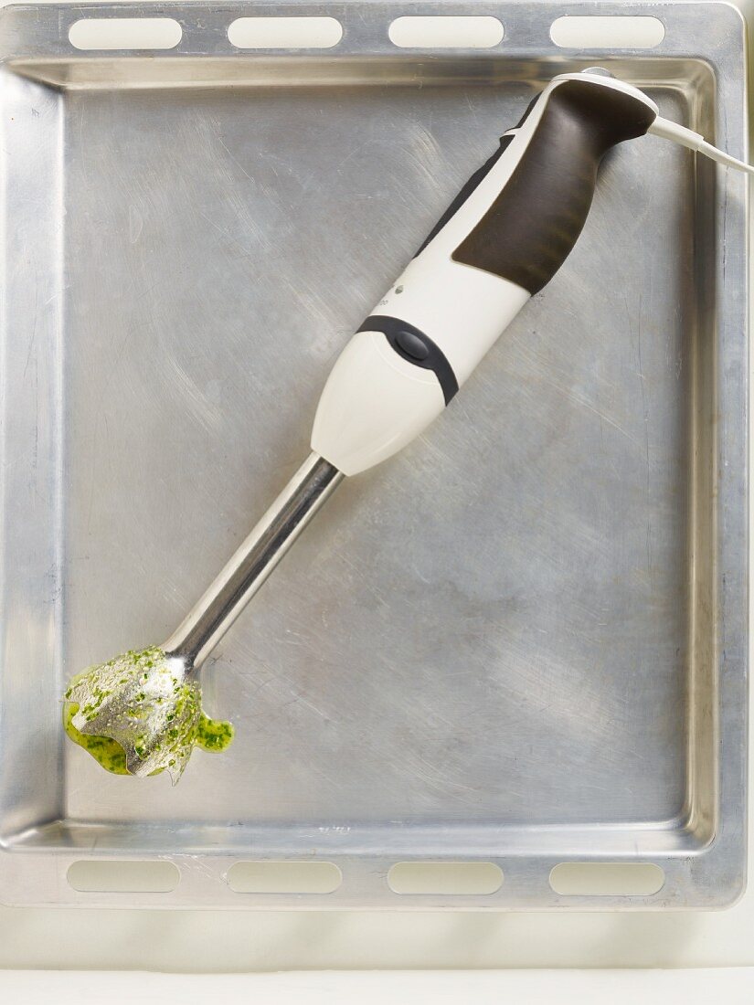 A used hand mixer on a baking tray (seen from above)