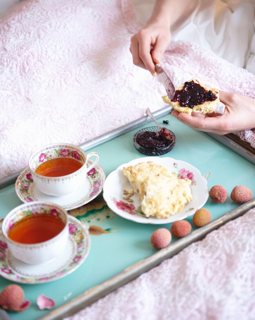 Breakfast in bed with spiced tea and sunflower seed and cheese scones with blueberry jam